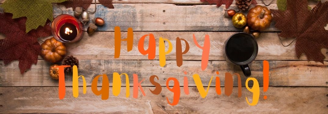 Thanksgiving Decorations on Wood Background with Fall-Colored Happy Thanksgiving Text