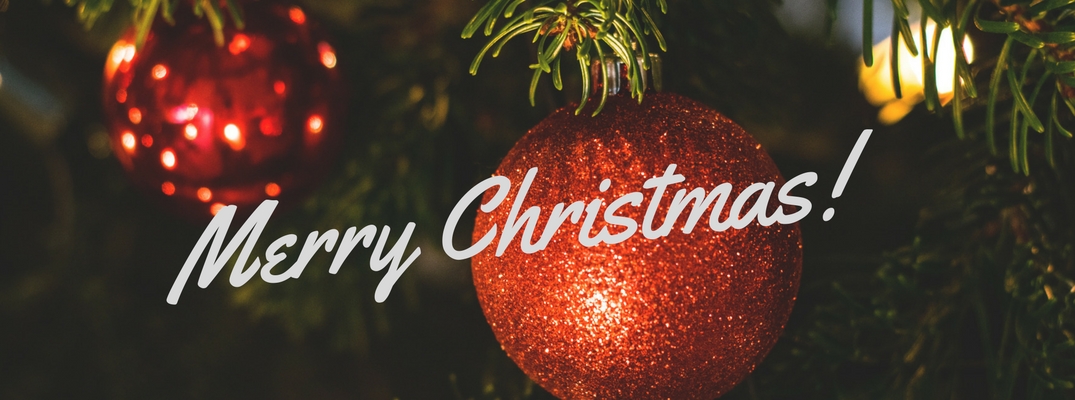 Close Up of Christmas Ornaments on a Tree with White Merry Christmas Text