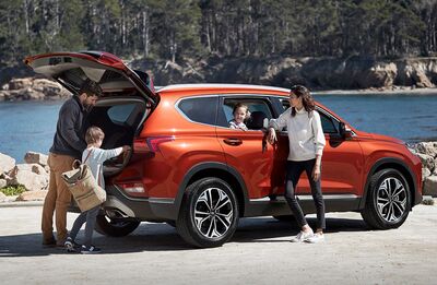 Family loading a Hyundai Santa Fe for a beach trip.