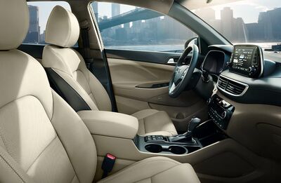 Hyundai Tucson interior with driver's seat and dashboard.