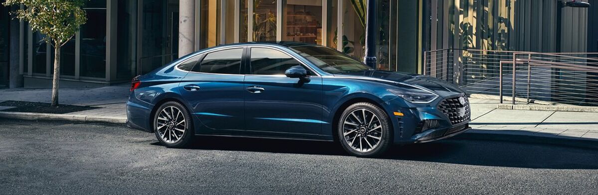 Blue Hyundai Sonata parked on a city street.
