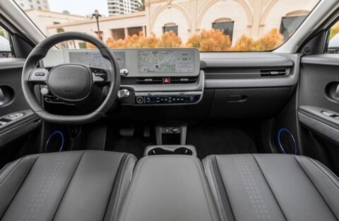 The interior of a Hyundai Ioniq 5, showing the driver's seat, steering wheel, and center console with a large touchscreen display.