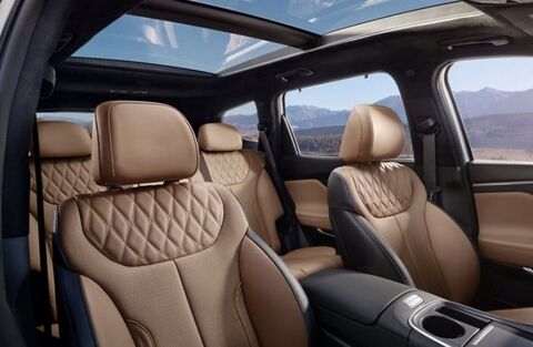 The interior of a Hyundai Santa Fe, showing the second row of seats with a panoramic sunroof above.
