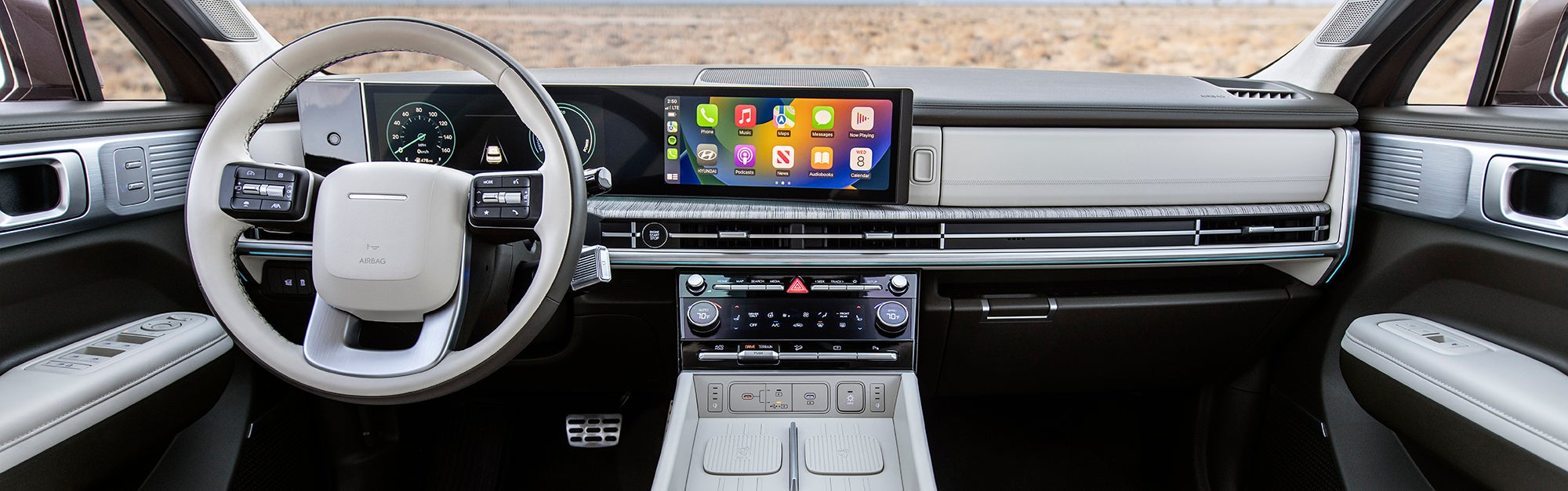The interior of a Hyundai Palisade, showcasing the driver's perspective. The image highlights the steering wheel, dashboard with a large touchscreen display, and a digital instrument cluster.