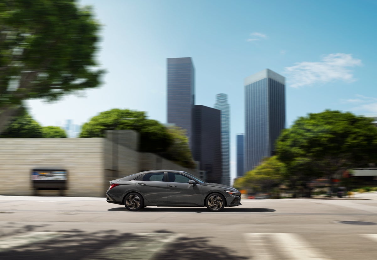 A silver 2026 Hyundai Elantra in Scottsdale drives to the right on a city street.