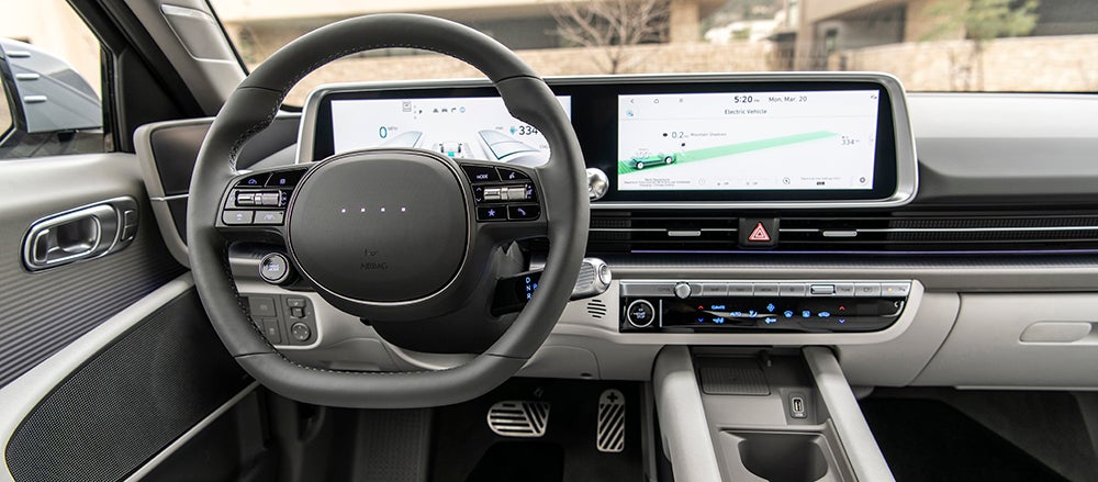 The dashboard of a Hyundai IONIQ 5, showing the connected digital instrument cluster and infotainment screens.