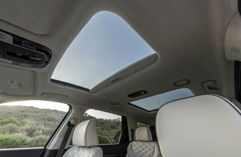 A panoramic sunroof in a Hyundai Palisade, showing the open sunroof and the interior with leather seats.