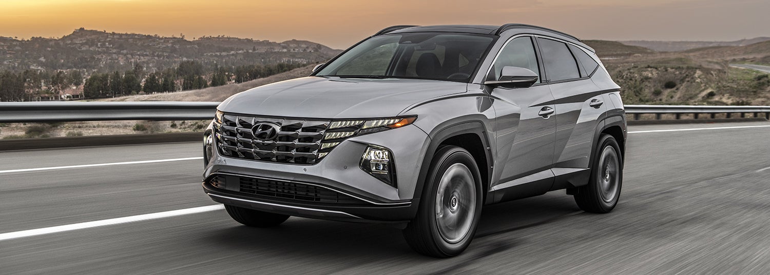 Silver Hyundai Tucson SUV driving on a highway.