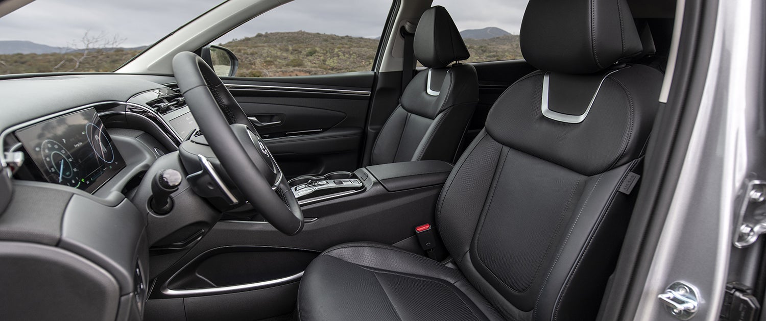 The interior of a Hyundai Palisade, showing the driver's seat and passenger seat. The seats appear to be upholstered in black leather with a quilted design.