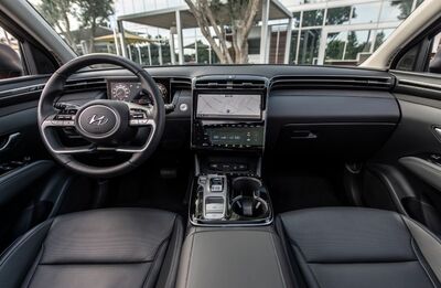 The interior of a Hyundai Palisade, showing the driver's seat, steering wheel, and dashboard with a large touchscreen display.