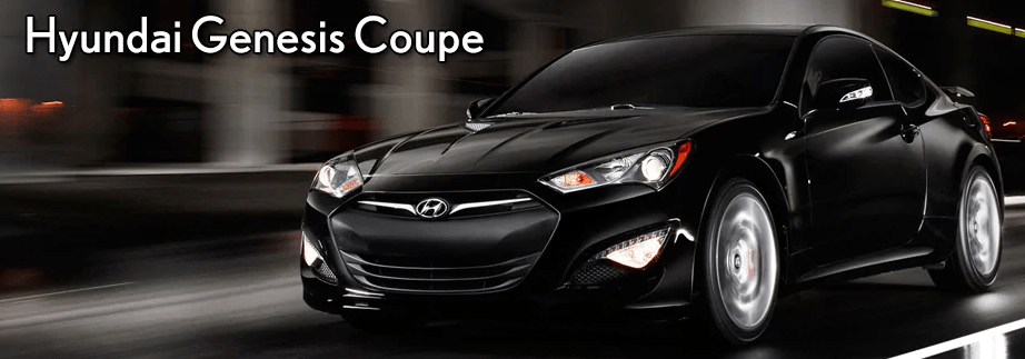 A black Hyundai Genesis Coupe speeding down a city street at night.